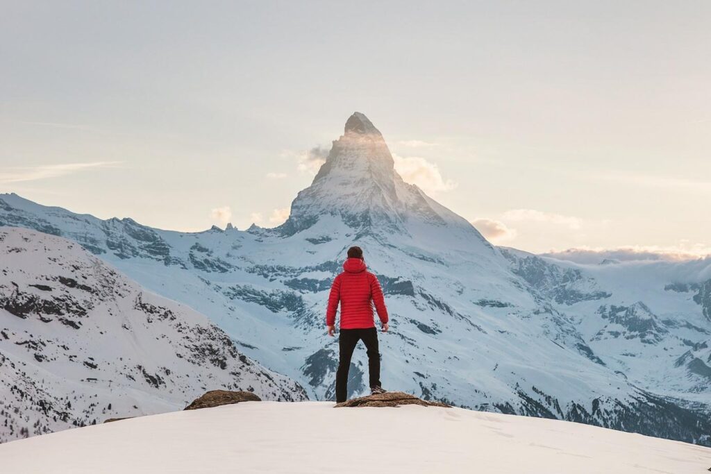 A person standing on a snowy mountain with Matterhorn in the backgroundAI-generated content may be incorrect.